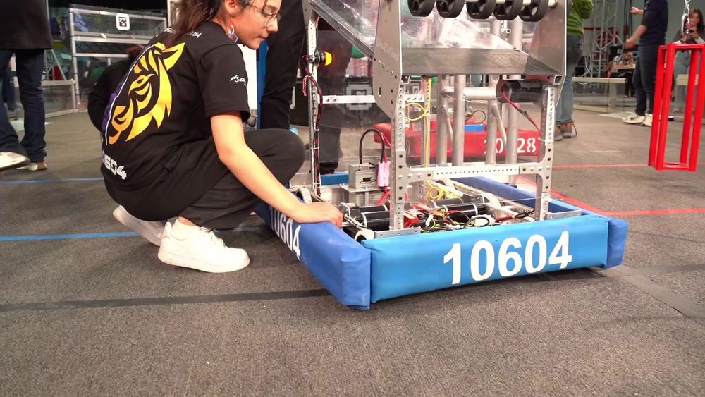 Bir takım üyesi pit alanında robot üzerinde çalışıyor